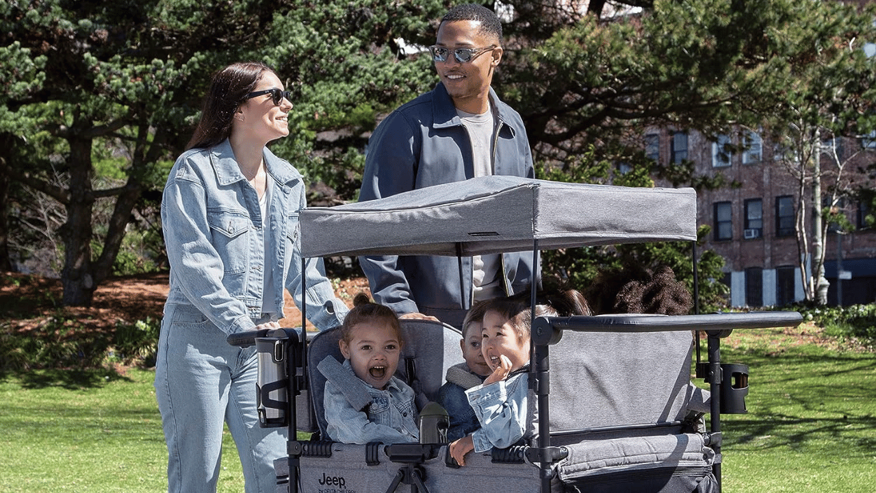 A family pushing a stroller wagon with kids in it